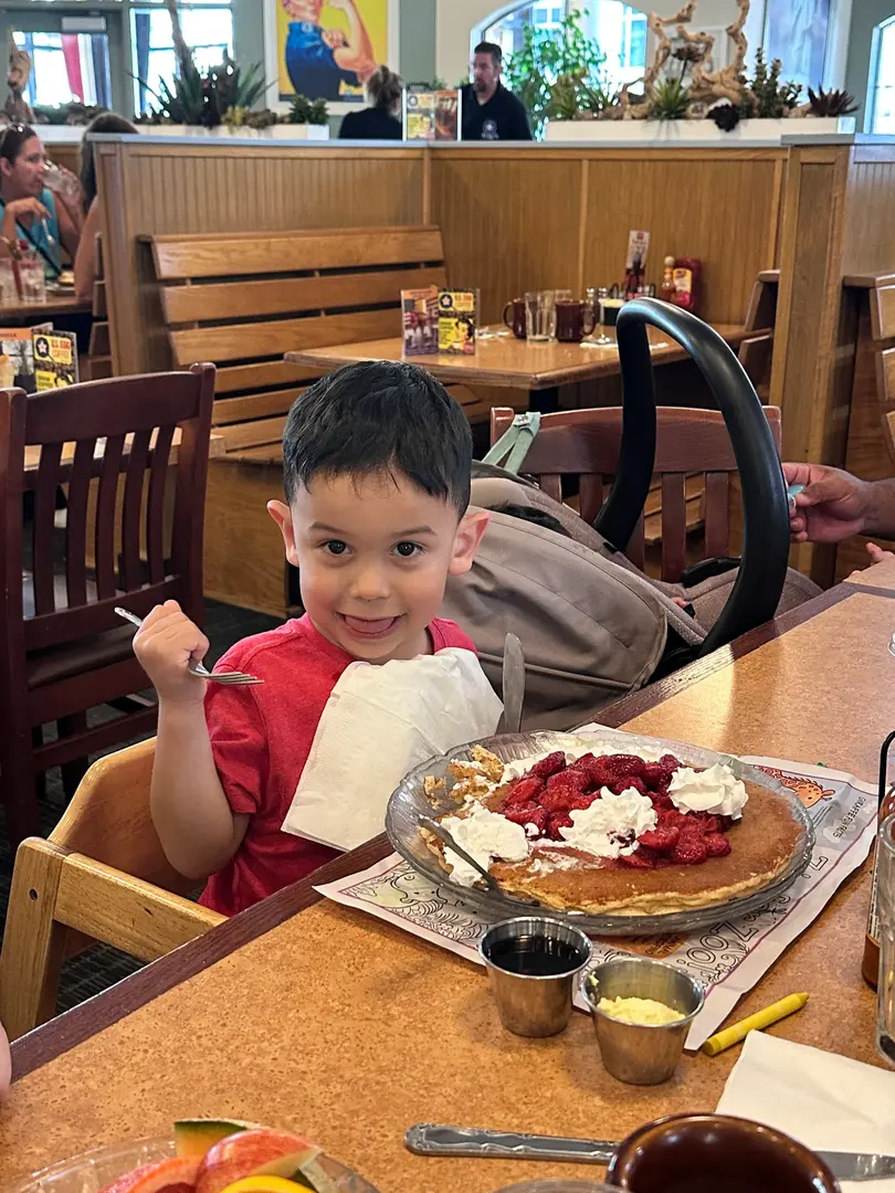 Child delighting in pancake breakfast