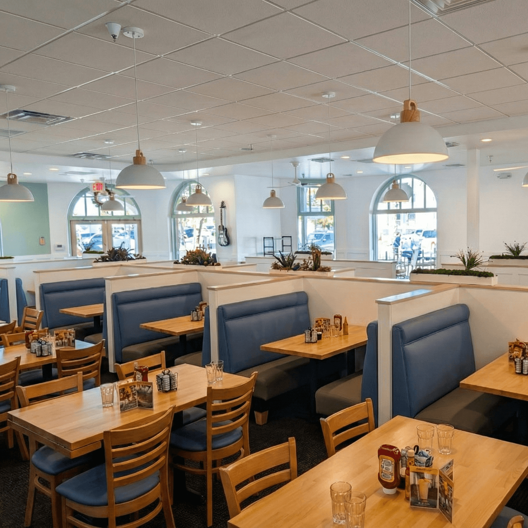 Bright dining room with blue booths at U.S. Egg Tempe