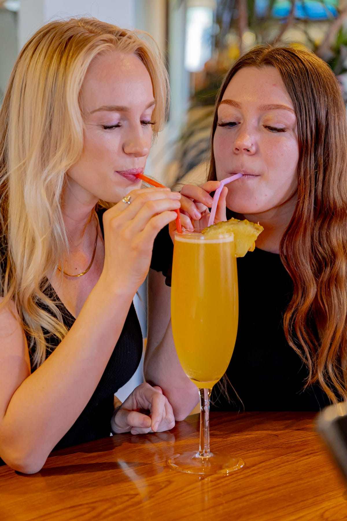 A glass of mimosa on a sunlit patio table at U.S. Egg