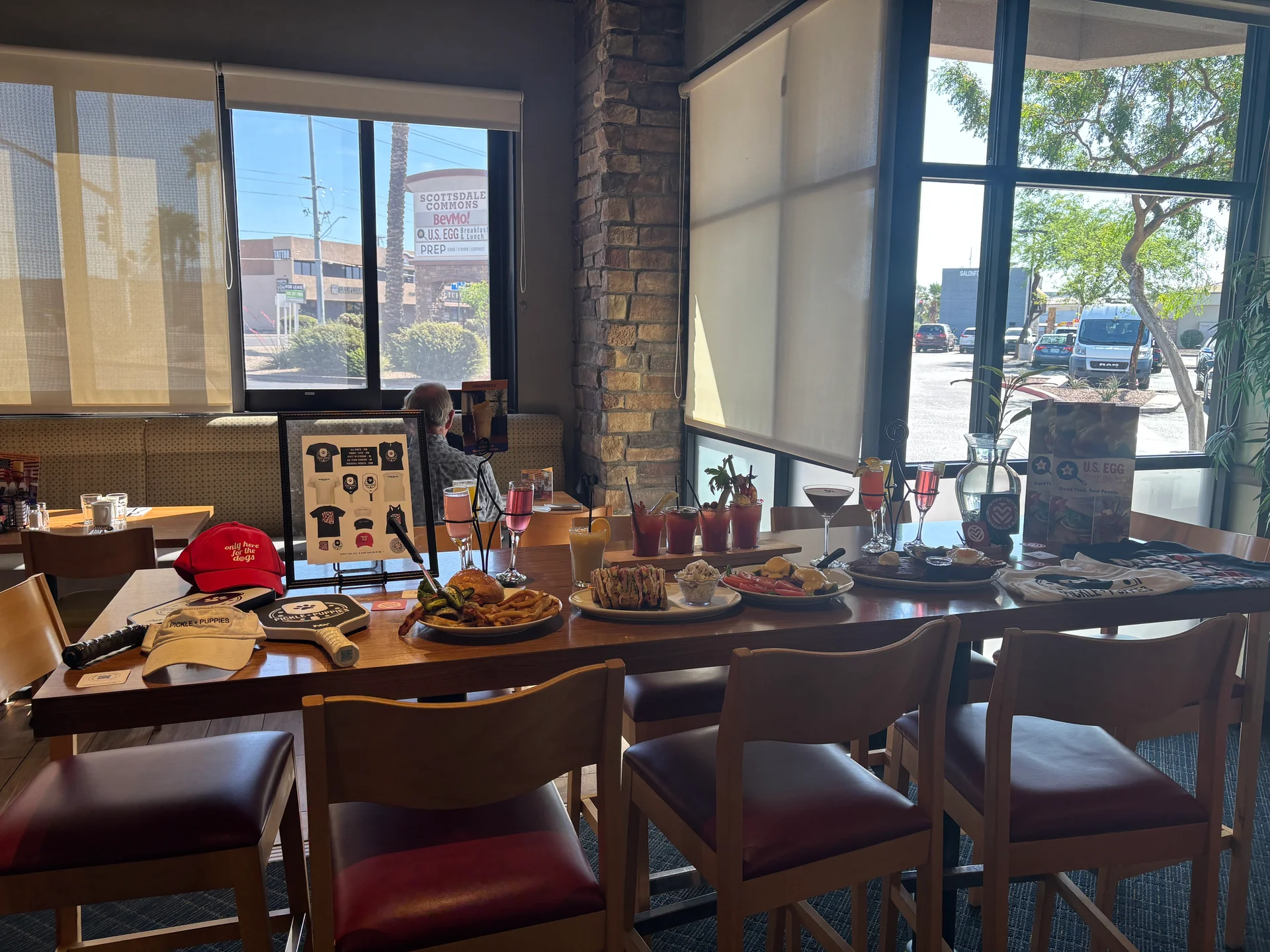 Rescue dogs and guests on the U.S. Egg North Scottsdale patio at the May 2, 2026 Heart of Infinity adoption event