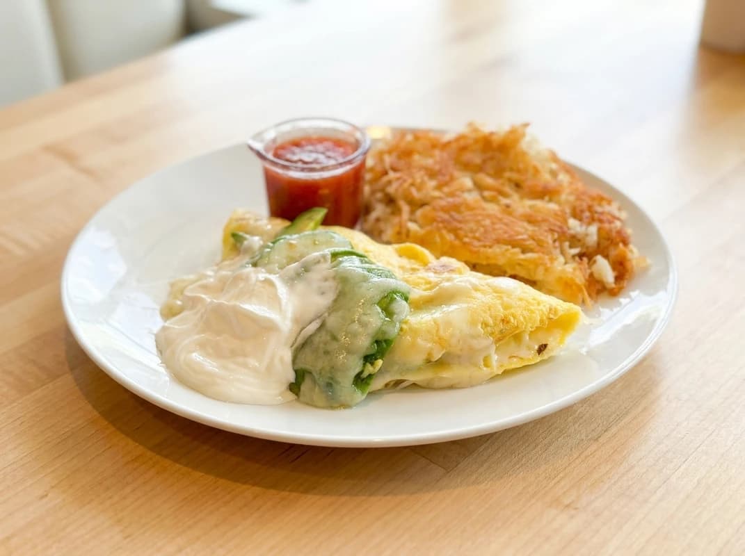 Avocado & Jack Omelette - Creamy avocado, melted jack cheese, sour cream, and a side of zesty salsa. California sunshine on a - U.S. Egg Breakfast & Lunch menu item (vegetarian)